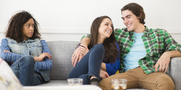 Couple ignoring friend on sofa